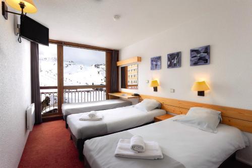 a hotel room with two beds and a balcony at Belambra Clubs Arc 2000 - L'Aiguille Rouge - Ski pass included in Arc 2000