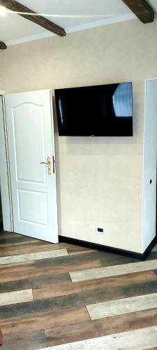 a living room with a door and a television on a wall at White House in Bălţi