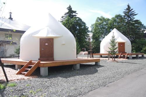 a group of three domes with a table and benches at K's House Hokkaido - Asahidake Onsen Hostel in Higashikawa