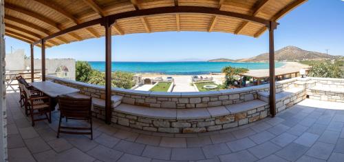 a patio with a table and chairs and the ocean at Avgerinos Village in Agiassos