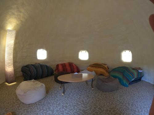 a room with a table and a bunch of ottomans at K's House Hokkaido - Asahidake Onsen Hostel in Higashikawa