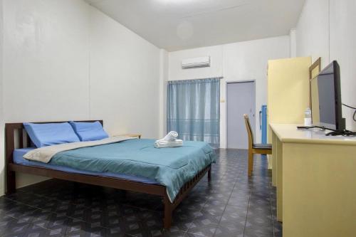 - une chambre avec un lit et un bureau avec une télévision dans l'établissement Monta Apartment, à Bang Saen