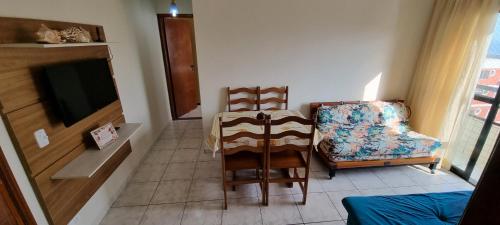 a living room with two chairs and a television at Apartamento Praia Grande na Tupi Frente Mar in Praia Grande