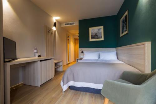 a bedroom with a large bed and a green wall at Casa Calfelor Kolping Timișoara in Timişoara