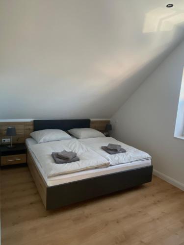 een bed in een kamer met een witte muur bij Ferienwohnung - Flüggenhofsee in Munster im Heidekreis
