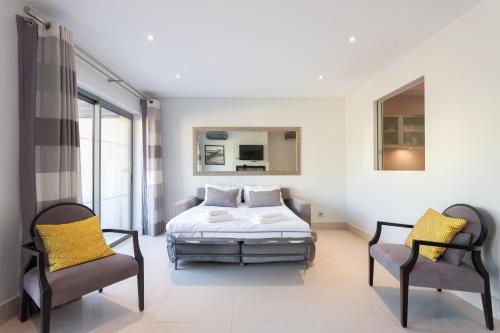 a bedroom with a bed and two chairs at Vilamoura Pine Hills Villa in Vilamoura