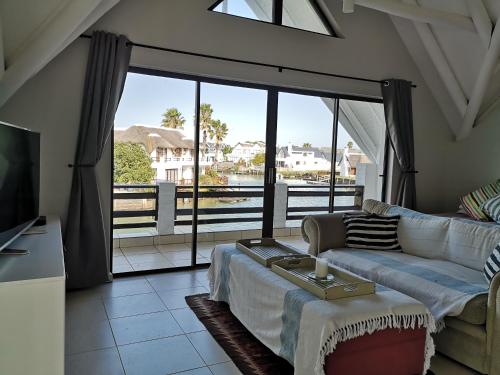 ein Wohnzimmer mit einem Sofa und einem großen Fenster in der Unterkunft St Francis Bay House On The Canal in St Francis Bay