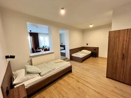 a large room with two beds and a mirror at Hotel i Restauracja „KRISTAL” in Braniewo