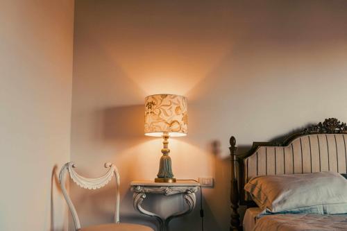 a lamp sitting on a table next to a bed at Bed and Breakfast Villa Romano in Anzio