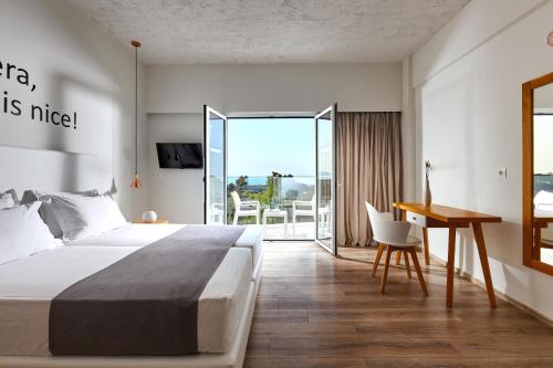 1 dormitorio con cama, escritorio y mesa en Vasia Royal Hotel, en Gouves