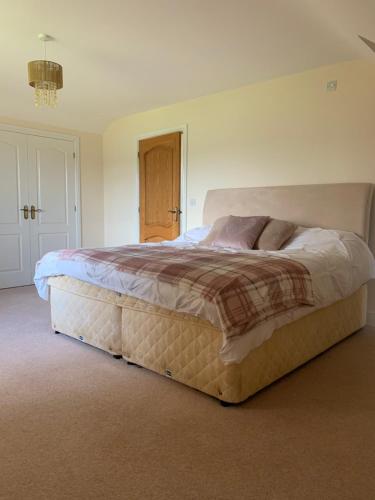 a bedroom with a large bed in a room at Captivating 4-Bed House in west Wales in Pencader