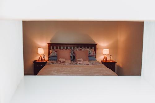 1 dormitorio con 1 cama grande y 2 lámparas en Lizzie's Cottage, en Drumaroad