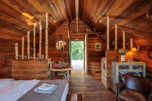 a bedroom in a log cabin with a bed and a table at Aqualodge Hôtel Insolite in Ermeton-sur-Biert