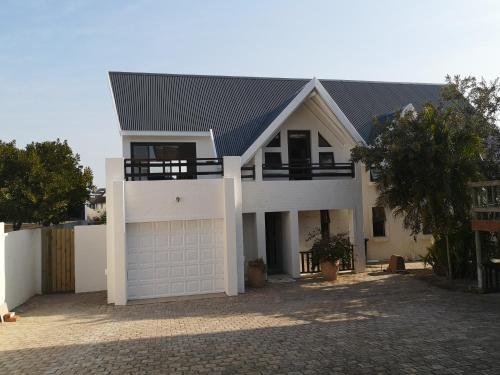 a white house with a garage at St Francis Bay House On The Canal in St Francis Bay