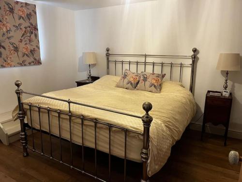 een slaapkamer met een metalen bed met kussens erop bij Byre - Farm Cottage on 9 acre Equestrian Small Holding in Salisbury