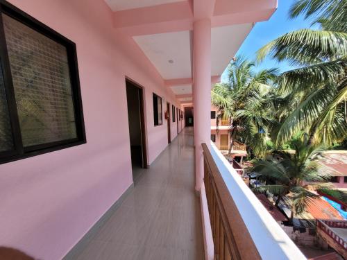 uma varanda de uma casa com palmeiras em Abbi's Nest Beach House Goa em Calangute