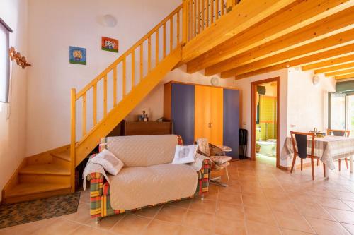 a living room with a staircase and a chair at Appartamento sul mare in Case Cicirello