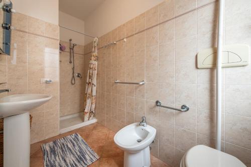La salle de bains est pourvue de toilettes, d'un lavabo et d'une douche. dans l'établissement Casa Vacanze 21 Aprile - 1, à Calasetta