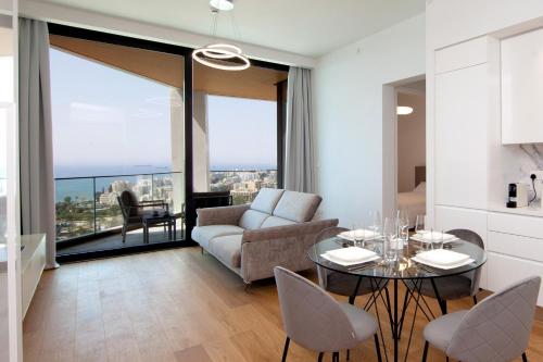 a living room with a couch and a table with chairs at Sky Tower in Limassol