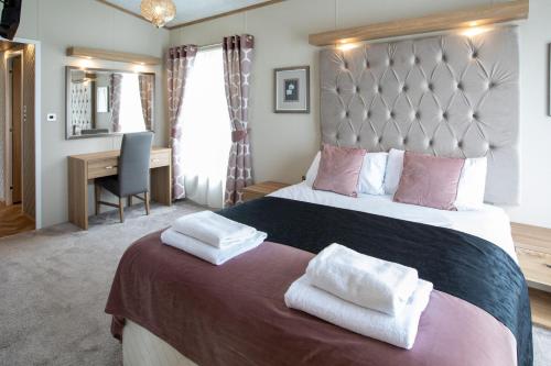 a bedroom with a large bed with two towels on it at Stewarts Resort Lodge 8 in St. Andrews