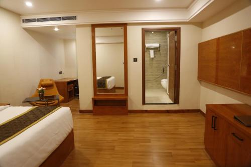 een kamer met een bed en een badkamer met een douche bij Leroy Grand - Yeshwanthpur in Bangalore