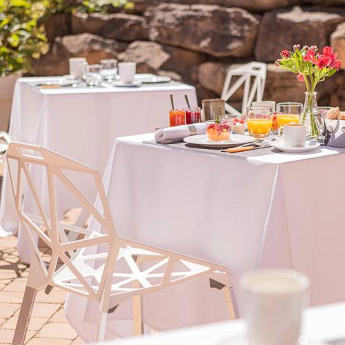 una mesa y sillas blancas con comida y bebida en La maison py en Vergisson