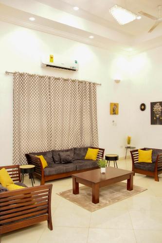 a living room with a couch and a table at Lovely 4 Bedroom Solar Powered House with CCTV and Unlimited WiFi near Devtraco Court Community 25 Tema in Tema