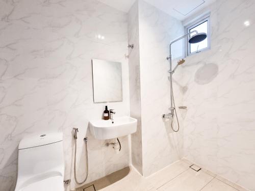 a white bathroom with a toilet and a sink at Twin Galaxy Suite by Nest Home in Johor Bahru