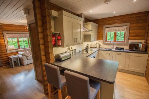a kitchen with a counter and chairs in a cabin at High Oaks Grange - Lodges in Pickering