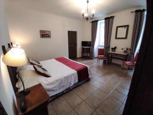 Ένα ή περισσότερα κρεβάτια σε δωμάτιο στο Logis Hôtel Restaurant Gîte La Bastide du Vébron