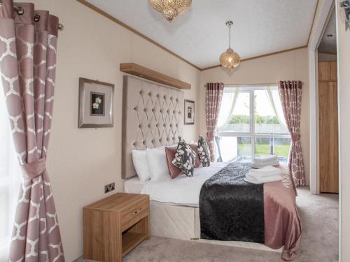 een slaapkamer met een bed en een raam bij Stewarts Resort Lodge 7 in St Andrews