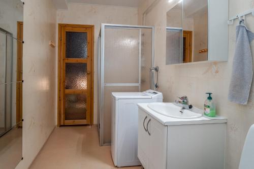 a bathroom with a sink and a washing machine at Best possible location, 1 bedroom apartment in Närpiö