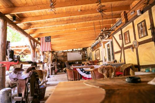 ein Restaurant mit Tischen und Stühlen und einer amerikanischen Flagge in der Unterkunft Longhorn Ranch Countryhotel - Garni in Schönau