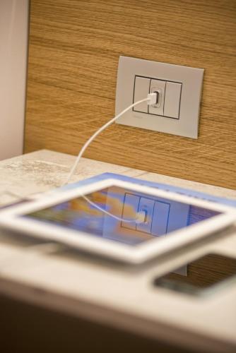 a cell phone is plugged into an electrical outlet at Hotel Giolli Nazionale in Rome