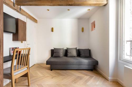 ein Wohnzimmer mit einem Sofa und einem Stuhl in der Unterkunft CMG- Charming appartement 2P - Batignolles in Paris