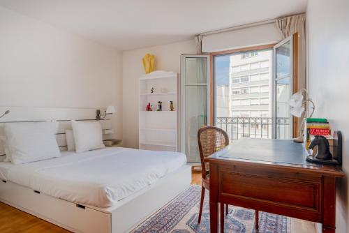 une chambre avec un lit, un bureau et une fenêtre dans l'établissement Beaudelaire Center Residence, à Paris