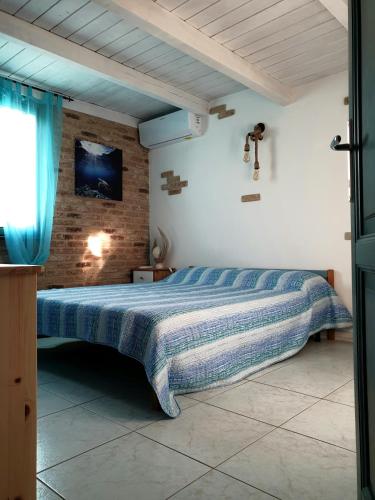 a bedroom with a bed with a blue comforter at Villa Panamàr in San Teodoro