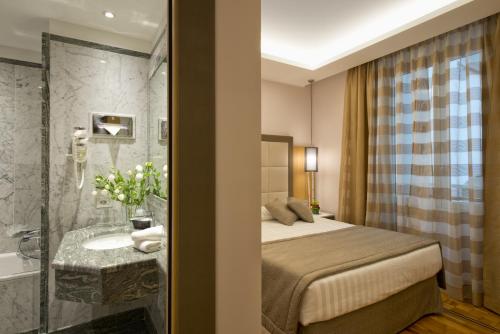 
a hotel room with a bed and a mirror at Hotel Giolli Nazionale in Rome
