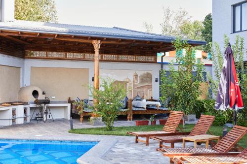 a patio with two chairs and a swimming pool at OLD TASHKENT Hotel & Spa in Tashkent