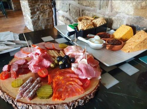 a table topped with a tray of meats and cheese at Sycamore Suite is a private retreat with log fire in Eckington