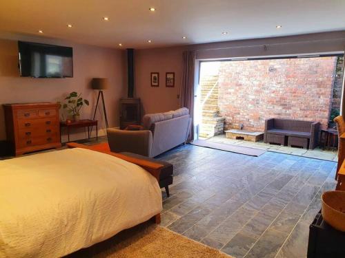 a bedroom with a bed and a large window at Sycamore Suite is a private retreat with log fire in Eckington