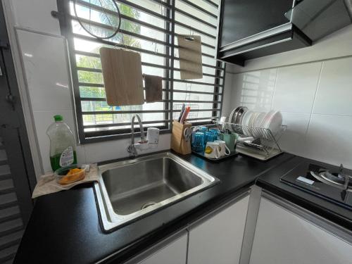 a kitchen counter with a sink and a window at kuala selangor homestay skymirror firefly in Kuala Selangor