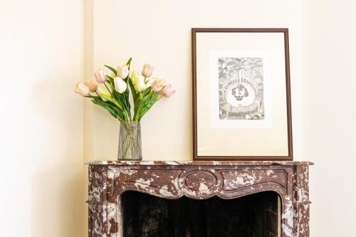 a vase of flowers sitting on top of a fireplace at Villa Caterina in La Maddalena