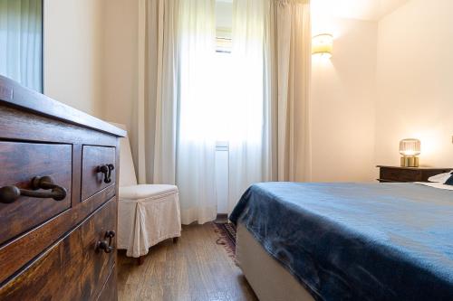 a bedroom with a bed and a dresser and a window at Villa Caterina in La Maddalena