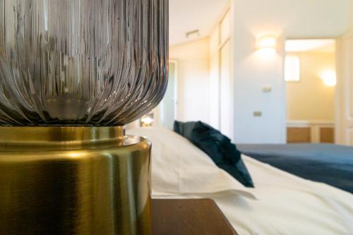 a metal vase sitting on a table next to a bed at Villa Caterina in La Maddalena
