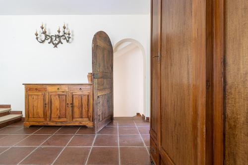 a hallway with a wooden door and a tiled floor at Villa Caterina in La Maddalena