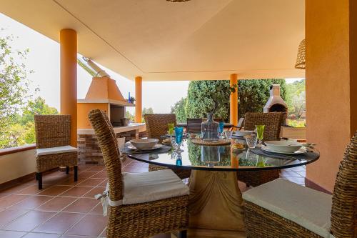 a dining room with a glass table and chairs at Villa Caterina in La Maddalena