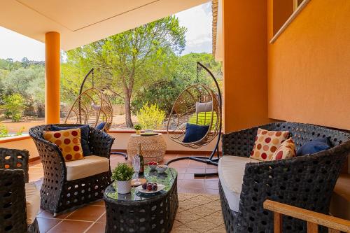 a porch with chairs and a table and a window at Villa Caterina in La Maddalena