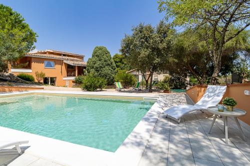a swimming pool with a table and a chair at Villa Caterina in La Maddalena