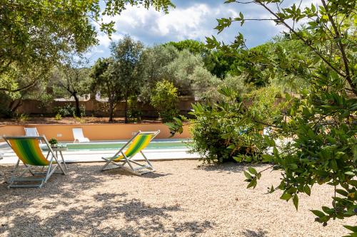 two lawn chairs sitting next to a swimming pool at Villa Caterina in La Maddalena